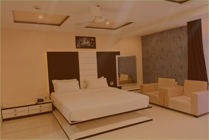 Hotel room with a large bed, nightstands, and a seating area